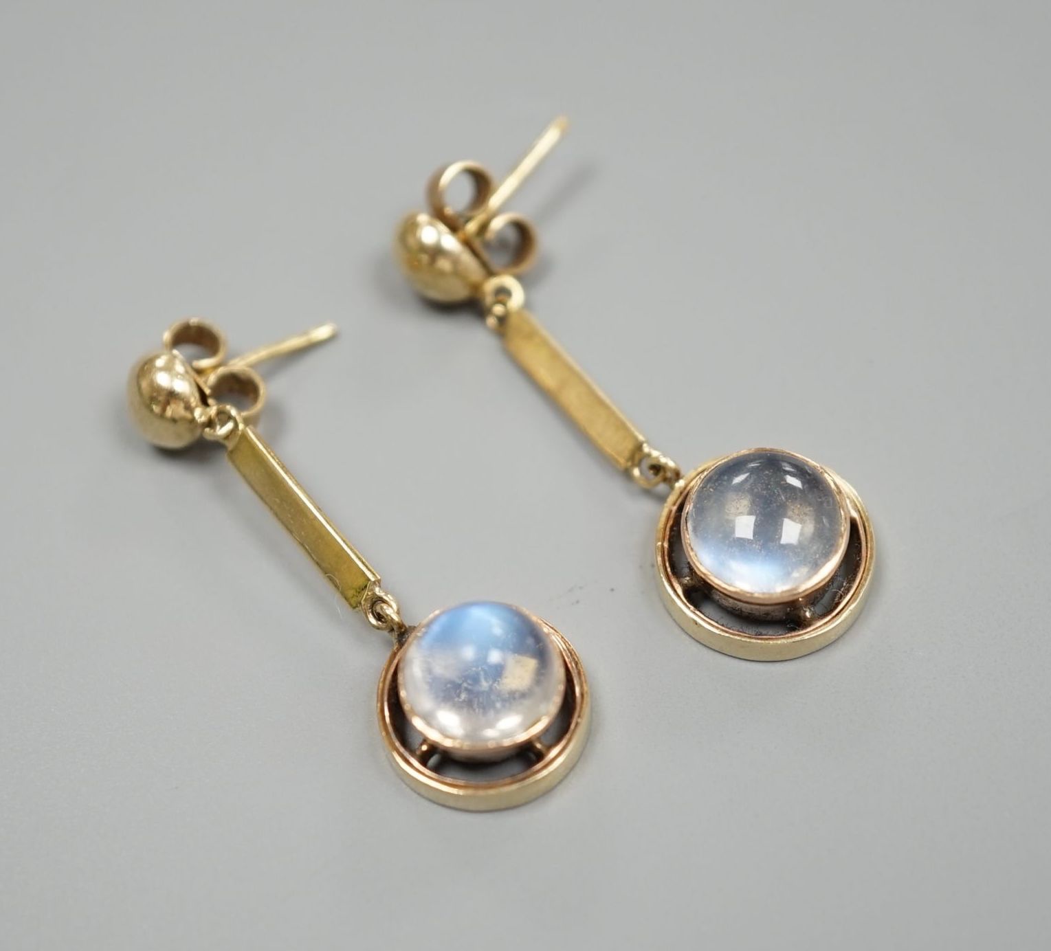 A pair of yellow metal and cabochon moonstone set drop earrings, 31mm, gross weight 4.8 grams.